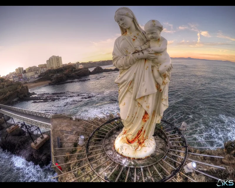 Statue de la Vierge à l'Enfant au sommet d'une falaise surplombant la mer au coucher du soleil — vue du dessus