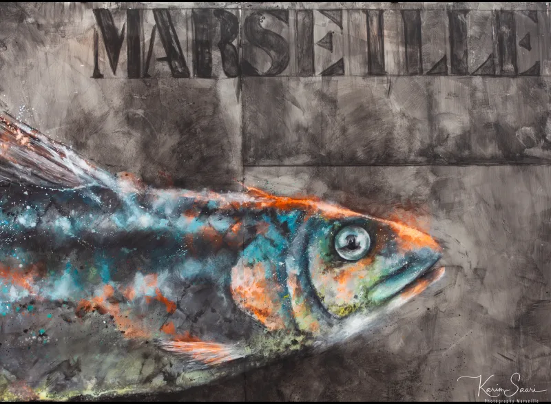 Street art marseillais — poisson coloré peint sous le mot MARSEILLE sur un mur de béton gris