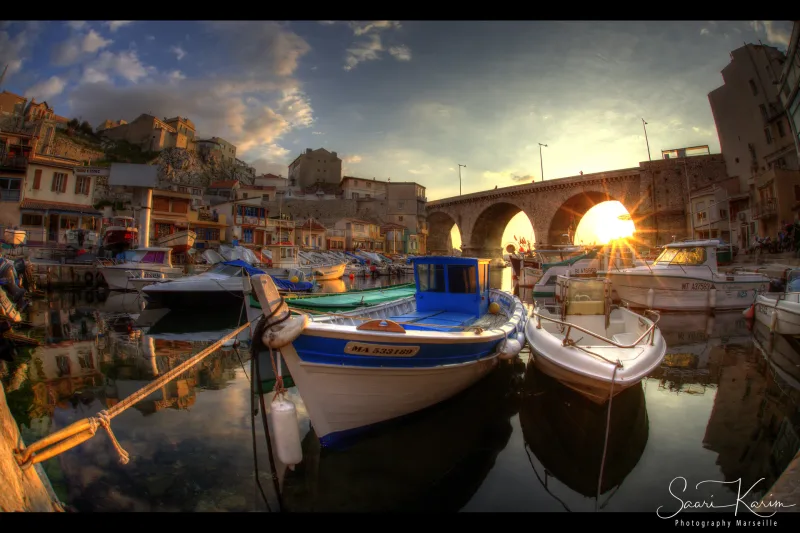 Port du Vallon des Auffes au coucher de soleil, barques colorées, pont en arches, soleil en étoile — Marseille