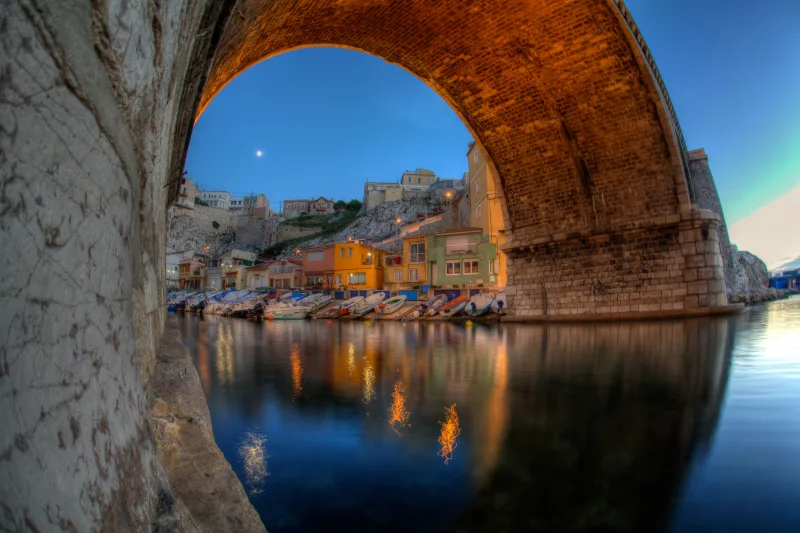 Port du Vallon des Auffes la nuit sous une arche de pont illuminée, maisons colorées et reflets dans l'eau — Marseille