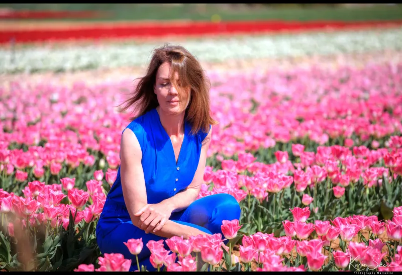 Femme en combinaison bleue dans un champ de tulipes roses — photographe paysage Provence Karim Saari
