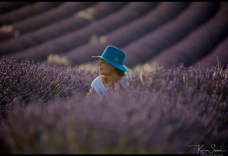 Femme au chapeau bleu dans un champ de lavande, lumière dorée du soir — photographe paysage Provence Karim Saari