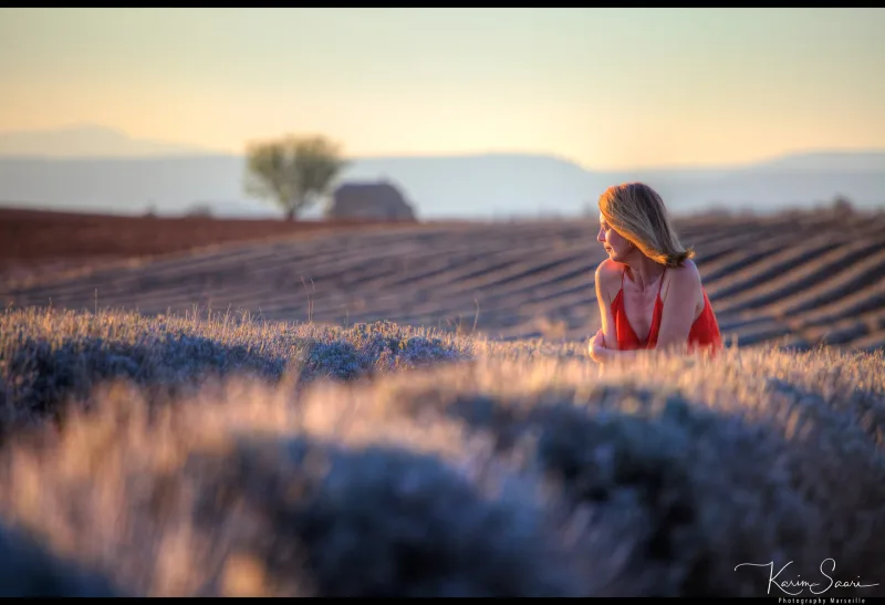 Femme en robe rouge dans la lavande au crépuscule, lumière dorée rasante — photographe Provence Karim Saari